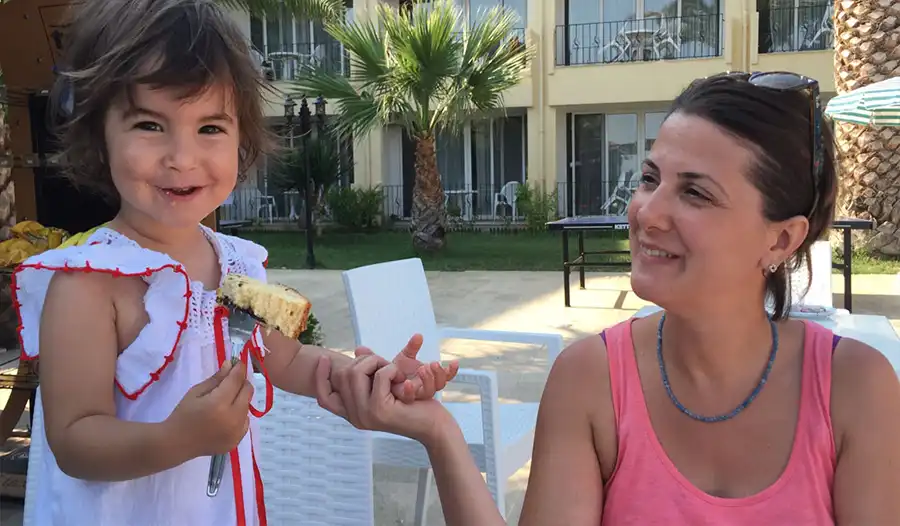 Elbis Hotel havuz cafede genç anne ve kek yiyen kız çocuğu - aile-otelleri 