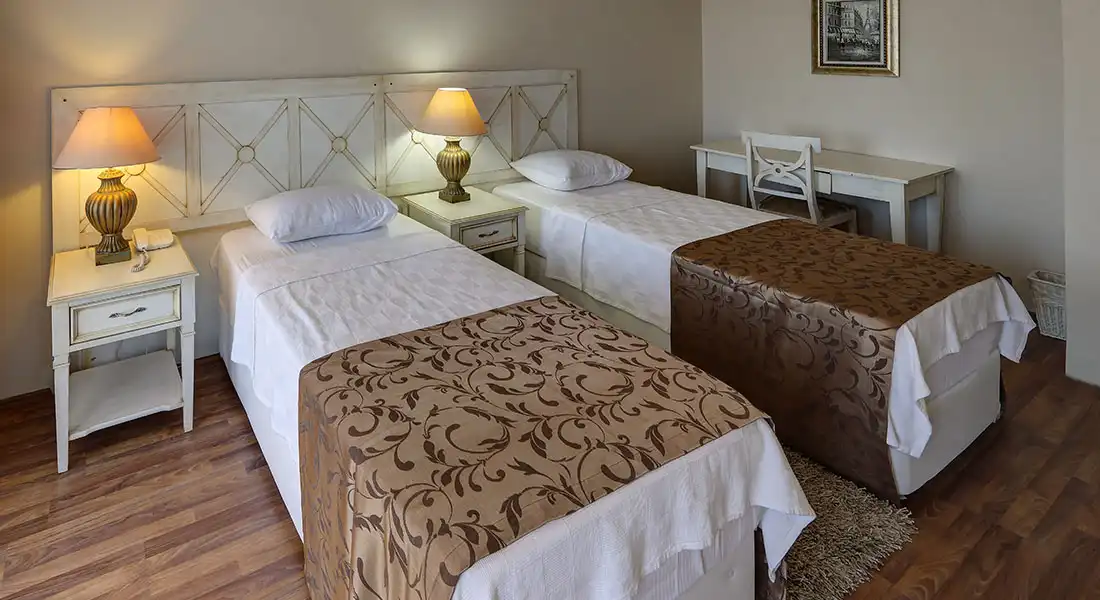 Elbis Hotel Altınoluk suit iki tek kişilik yataklı bölümü ve çalışma masası 